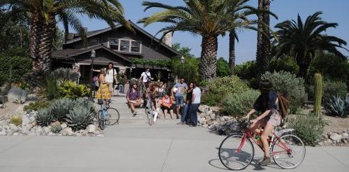 an exterior shot of the grove house with several students hanging out on the steps in front